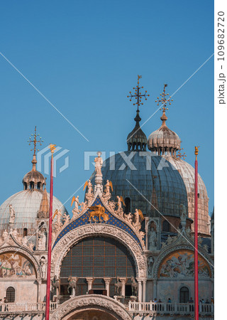 Ornate Gothic cathedral in Venice, Italy, with stunning architectural details and towering spires against a blue sky. A standout landmark in the city. 109682720