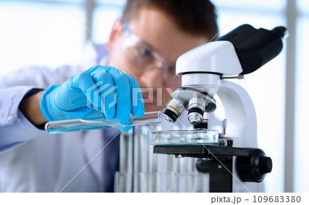 A male chemist holds test tube of glass in his hand 109683380