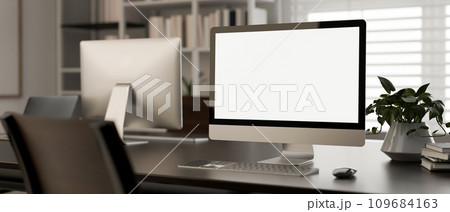 A white-screen PC computer mockup on a desk in a modern office room. workspace close-up image. 109684163