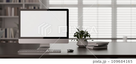 Front view of a modern workspace in a modern office room with a PC desktop computer mockup on a desk 109684165