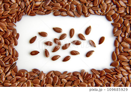Frame of flax seeds scattered on a white background. View from above. Dedicated Focus 109685929