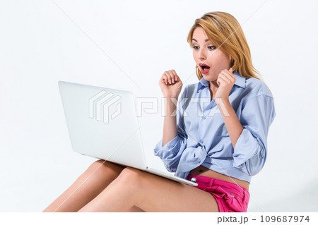 young woman sitting on the floor and using laptop 109687974
