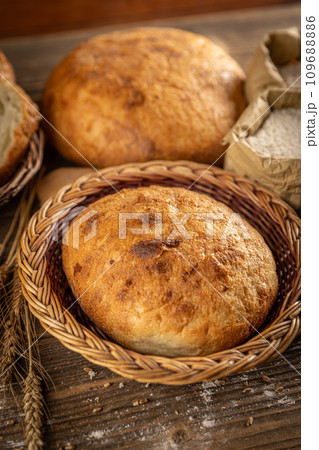 Whole fresh bread in wicker basket 109688886
