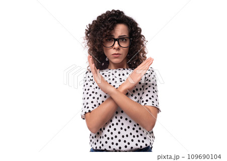 young confident leader woman with curly hairstyle dressed in summer blouse crossed her arms in front young confident leader woman with curly hairstyle dressed in summer blouse crossed her arms in front 109690104
