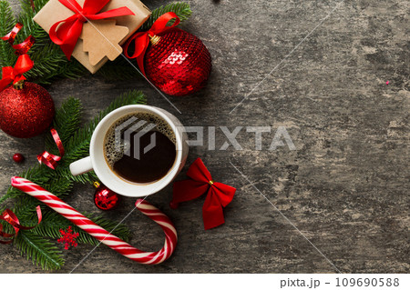 Delicious fresh festive morning coffee in a ceramic cup with little wrapped gifts, ornament and xmas toy. Cup of coffee and new year toys 109690588