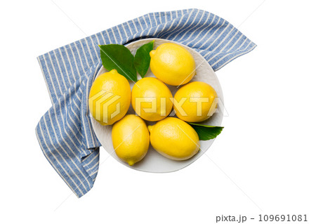 Fresh cutted lemon and whole lemons over round plate isolated on white background. Food and drink ingredients preparing. healthy eating theme top view with copy space Fresh cutted lemon and whole lemons over round plate isolated on white background. Food and drink ingredients preparing. healthy eating theme top view with copy space 109691081