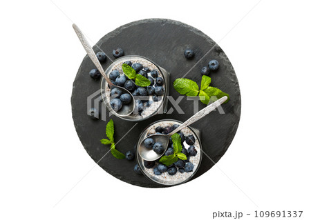 Healthy breakfast or morning with chia seeds vanilla pudding and blueberry berries on table background, vegetarian food, diet and health concept. Chia pudding with coconut milk and blueberry Healthy breakfast or morning with chia seeds vanilla pudding and blueberry berries on table background, vegetarian food, diet and health concept. Chia pudding with coconut milk and blueberry 109691337