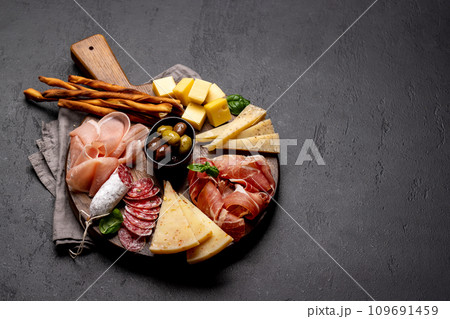 Antipasto board with various meat and cheese snacks Antipasto board with various meat and cheese snacks 109691459