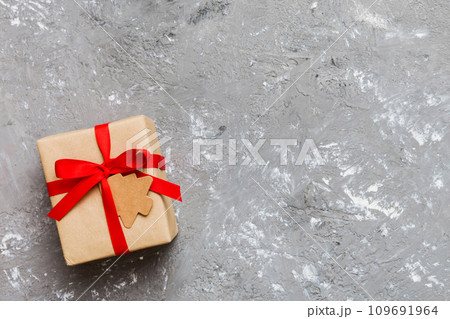 wrapped christmas or other holiday handmade present in paper with colored ribbon. Present box, decoration of gift on colourfull table, top view with copy space 109691964