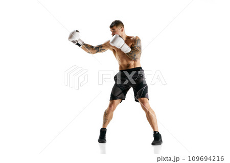 Muscular strong athletic young guy, athlete training, boxing isolated over white background. Strong hands Muscular strong athletic young guy, athlete training, boxing isolated over white background. Strong hands 109694216