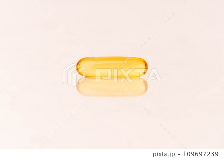 Close up of oil softgel capsules on white background with reflection. Nutritional supplement contains fish oil, omega 3, omega 6, omega 9, vitamin e, vitamin d and vitamin a. Selective focus. Close up of oil softgel capsules on white background with reflection. Nutritional supplement contains fish oil, omega 3, omega 6, omega 9, vitamin e, vitamin d and vitamin a. Selective focus. 109697239