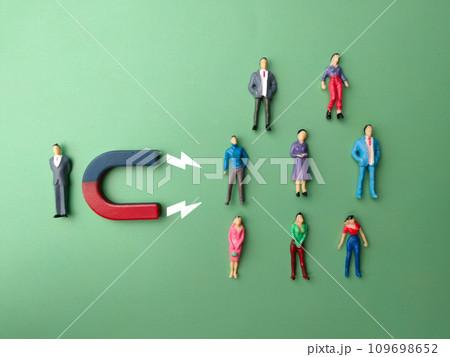Top view miniature businessman attracts people using magnet. Business concept. Top view miniature businessman attracts people using magnet. Business concept. 109698652