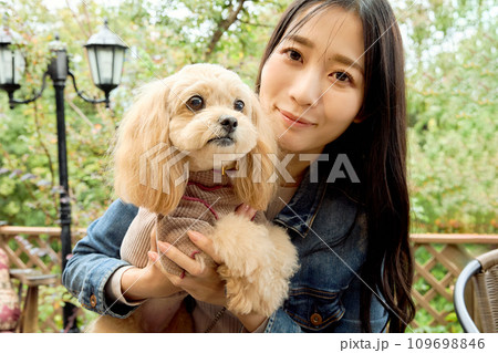 ドッグカフェで愛犬と触れ合う女性 109698846
