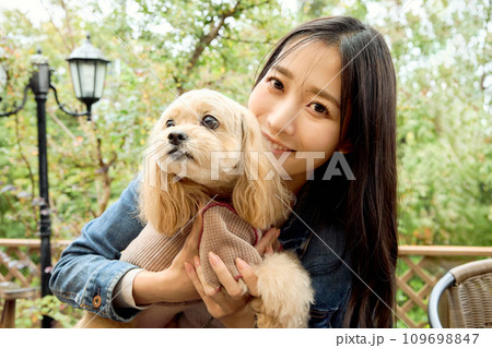 ドッグカフェで愛犬と触れ合う女性 109698847
