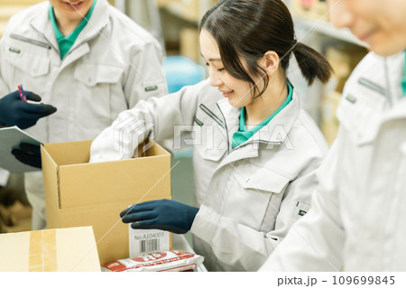 倉庫で箱詰めをする若いスタッフ 倉庫で箱詰めをする若いスタッフ 109699845