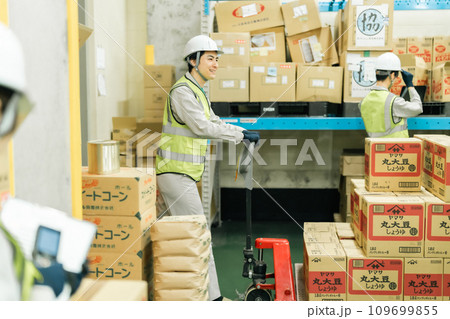 ジャッキでパレットを移動させる倉庫管理者 109699855