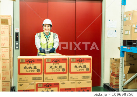 ジャッキでパレットを移動させる在庫管理者 109699856