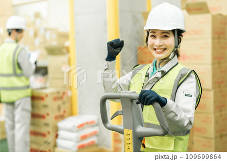 ジャッキで在庫移動をするガッツポーズの女性作業員 ジャッキで在庫移動をするガッツポーズの女性作業員 109699864