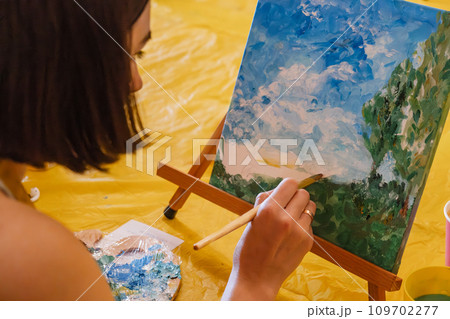 Woman with brush painting on canvas 109702277