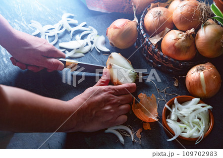 Brown onions and slices on wooden cutting board.Healthy food background 109702983