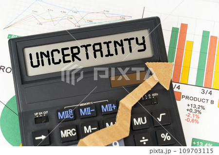 On the business charts there is a calculator on the screen with the inscription - Uncertainty On the business charts there is a calculator on the screen with the inscription - Uncertainty 109703115