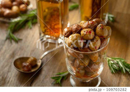 Spicy olives and bottles of olive oil on a wooden table. 109703282