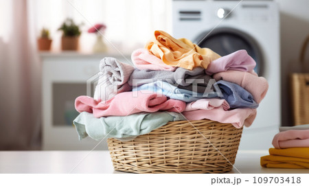 Laundry day, wicker basket with freshly laundered clothes in variety of soft, pastel hues, with washing machine in background, home laundry room, household chores Laundry day, wicker basket with freshly laundered clothes in variety of soft, pastel hues, with washing machine in background, home laundry room, household chores 109703418