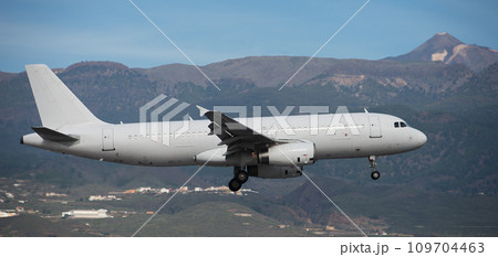 The plane lands.Airplane, passengers flying in the sky, preparing to land at the airport. El Teide volcano in the background 109704463