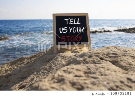 Tell us your story symbol. Concept words Tell us your story on black chalk blackboard. Beautiful sea background. Business and Tell us your story concept. Copy space. Tell us your story symbol. Concept words Tell us your story on black chalk blackboard. Beautiful sea background. Business and Tell us your story concept. Copy space. 109705191