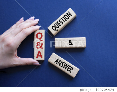 Q and A - Question and Answer. Wooden cubes with words Q and A. Businessman hand. Beautiful deep blue background. Business and Q and A concept. Copy space. 109705474