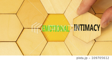 Emotional intimacy symbol. Concept words Emotional intimacy on beautiful wooden puzzle. Beautiful yellow table yellow background. Psychologist hand. Psychology emotional intimacy concept. Copy space. 109705612
