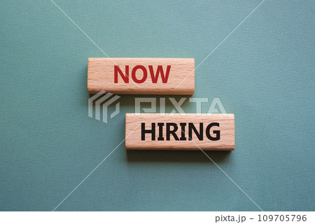 Now Hiring symbol. Concept word Now Hiring on wooden blocks. Beautiful grey green background. Business and Now Hiring concept. Copy space 109705796