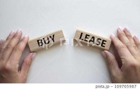 Buy or Lease symbol. Concept word Buy or Lease on wooden blocks. Businessman hand. Beautiful white background. Business and Buy or Lease concept. Copy space Buy or Lease symbol. Concept word Buy or Lease on wooden blocks. Businessman hand. Beautiful white background. Business and Buy or Lease concept. Copy space 109705987