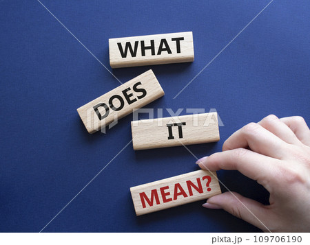 What does it mean symbol. Wooden blocks with words What does it mean. Beautiful deep blue background. Businessman hand. Business and What does it mean concept. Copy space. 109706190