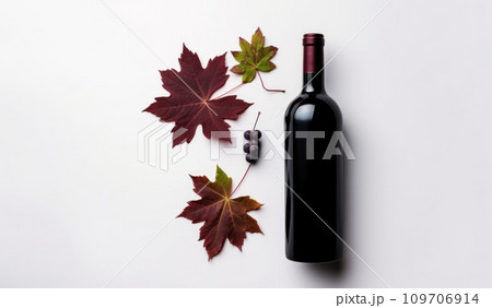 red wine bottle with autumn leaves on a white background 109706914