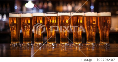 a row of beer glasses lined up in a bar 109708407
