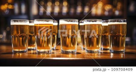 a row of beer glasses lined up in a bar a row of beer glasses lined up in a bar 109708409