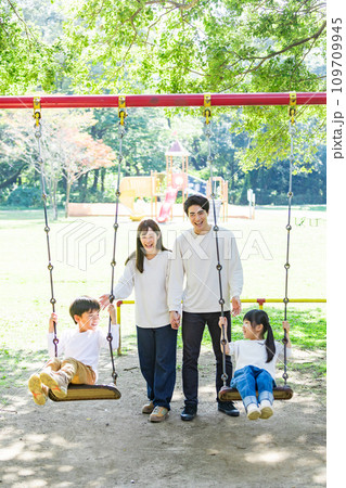 公園のブランコで遊ぶ仲良しな家族 109709945