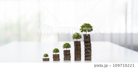 Growth coin stack with tree on top symbolize green business investment. Shrewd Growth coin stack with tree on top symbolize green business investment. Shrewd 109710221