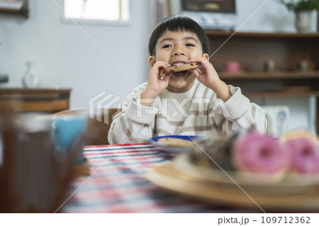 クッキーを食べる7歳の男の子　 109712362