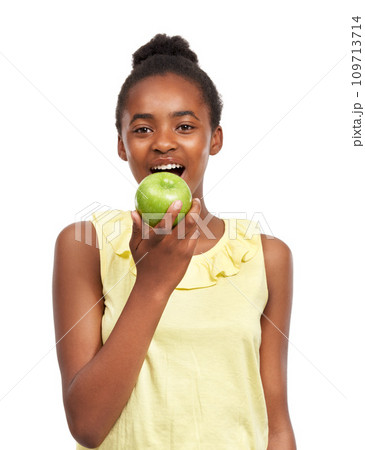 Eating, smile with portrait of girl and apple in studio for nutrition, wellness and diet. Food, self care and vitamin c with face of African student and fruit on white background for fiber and health Eating, smile with portrait of girl and apple in studio for nutrition, wellness and diet. Food, self care and vitamin c with face of African student and fruit on white background for fiber and health 109713714
