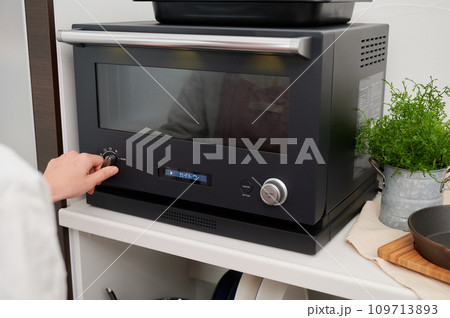 電子レンジを操作する女性　料理　手 109713893