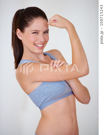 Woman, portrait or smile in studio with flex for fitness, wellness or workout strength with sportswear. Person, athlete or happy for biceps, exercise and training on white background or mock up space 109715243