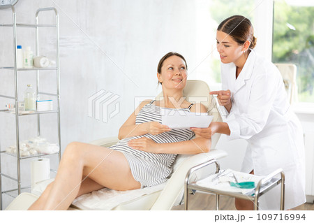 Woman doctor give patient medical documents for review before carrying out cosmetic procedure 109716994