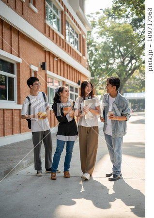 Group of diverse happy Asian college students are enjoying talking after classes on a footpath. Group of diverse happy Asian college students are enjoying talking after classes on a footpath. 109717068
