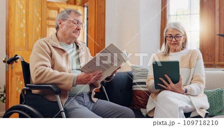 Elderly couple and care, retirement house and wheelchair in nursing home with people reading books, news or tablet with hobbies. Retirement and relax in house living room with notebook 109718210