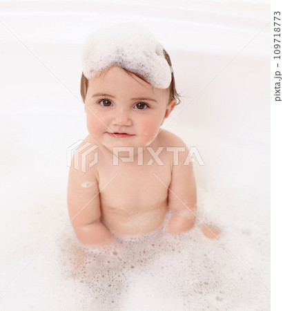 Baby in bath with soap, water and portrait of clean fun in for skincare, wellness and hygiene. Bubbles in bathtub, foam and child in bathroom with cute face, care and washing dirt, germs and smile. Baby in bath with soap, water and portrait of clean fun in for skincare, wellness and hygiene. Bubbles in bathtub, foam and child in bathroom with cute face, care and washing dirt, germs and smile. 109718773