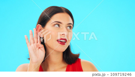 Secret, gossip and woman in blue studio background for beauty and listening. Whisper, frame and privacy with makeup, headshot and isolated for cupping ear, rumour and thinking for spy, emoji or talk 109719246