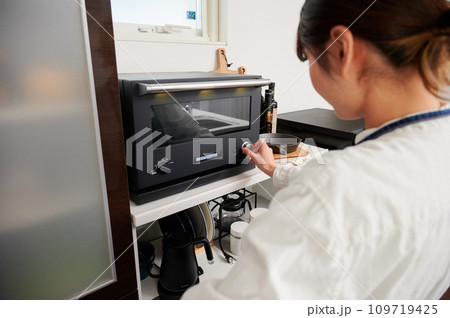 電子レンジを操作する女性　料理　 109719425