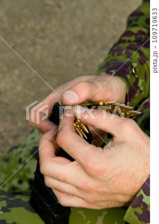 Man, soldier hands and bullet for a gun outdoor with military training, battle and conflict. Army, war and field with a male tactical expert of a hero with weapon for shooting range and warrior gear 109719633